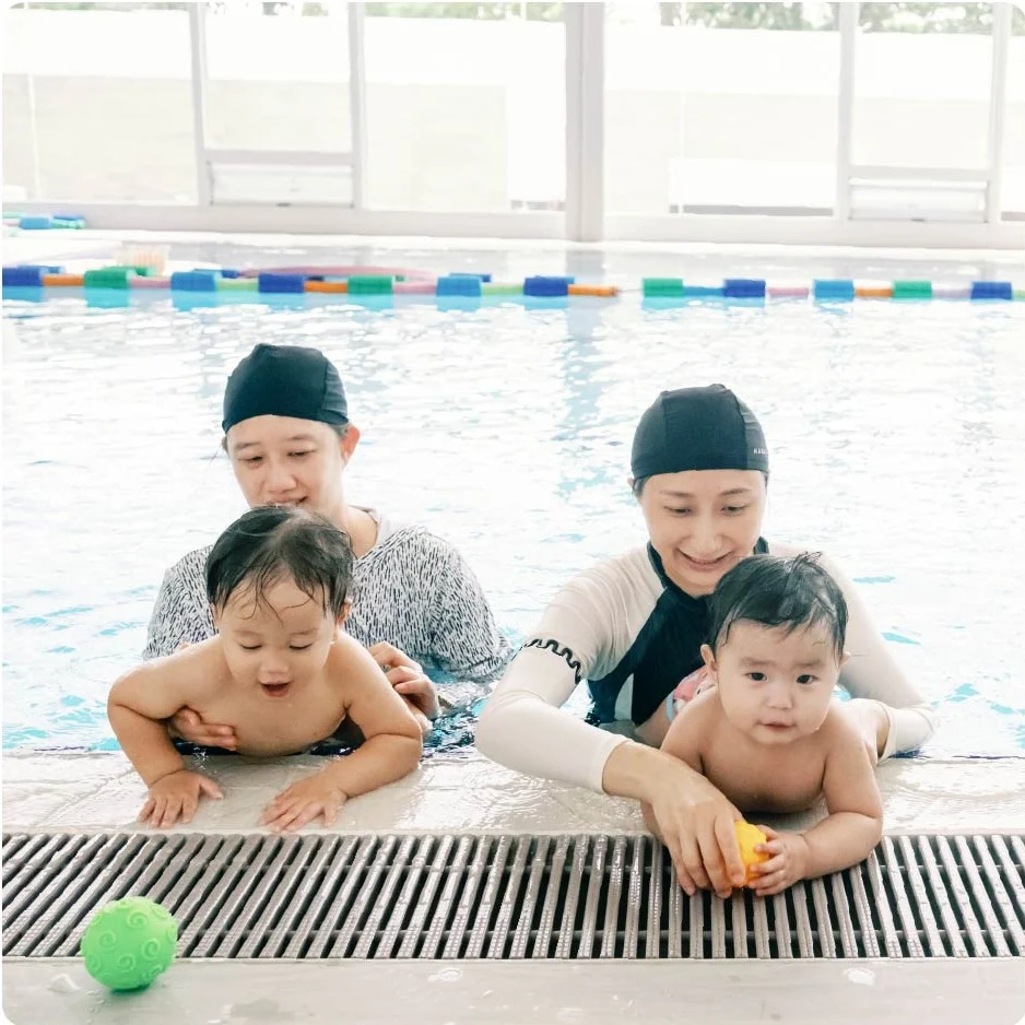 家長陪伴兩名幼兒在池邊練習