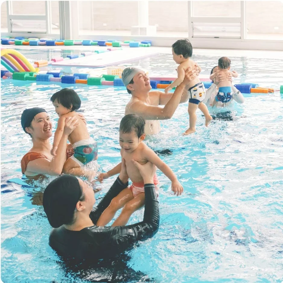 多組親子在泳池中進行團體活動